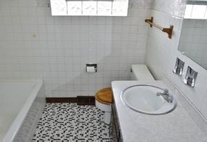 bathroom with tile patterned floors, tile walls, and a healthy amount of sunlight