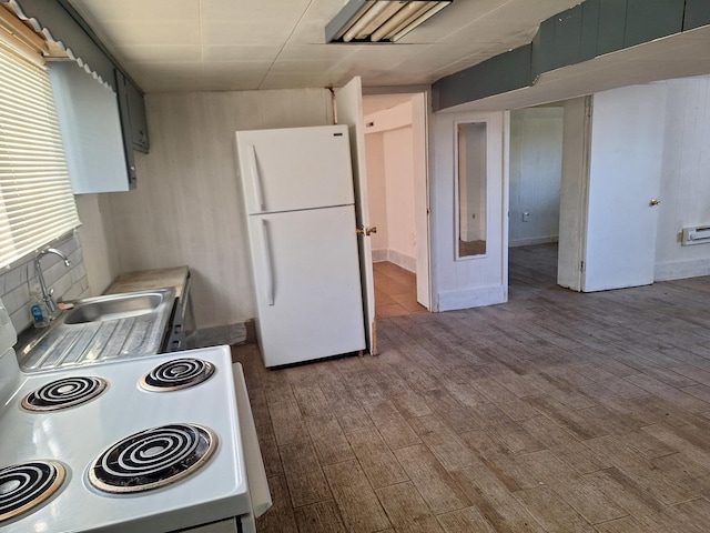 kitchen featuring light hardwood / wood-style flooring, white appliances, and sink