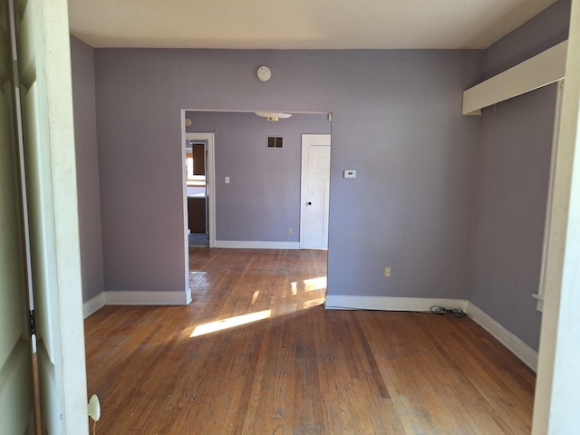 empty room with hardwood / wood-style flooring