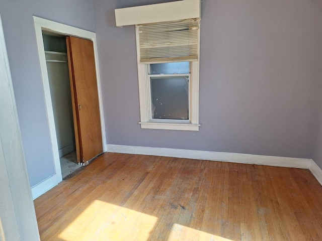 unfurnished bedroom with light wood-type flooring and a closet