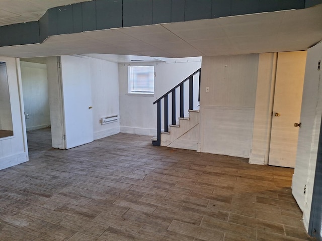 basement featuring a wall mounted air conditioner and hardwood / wood-style floors