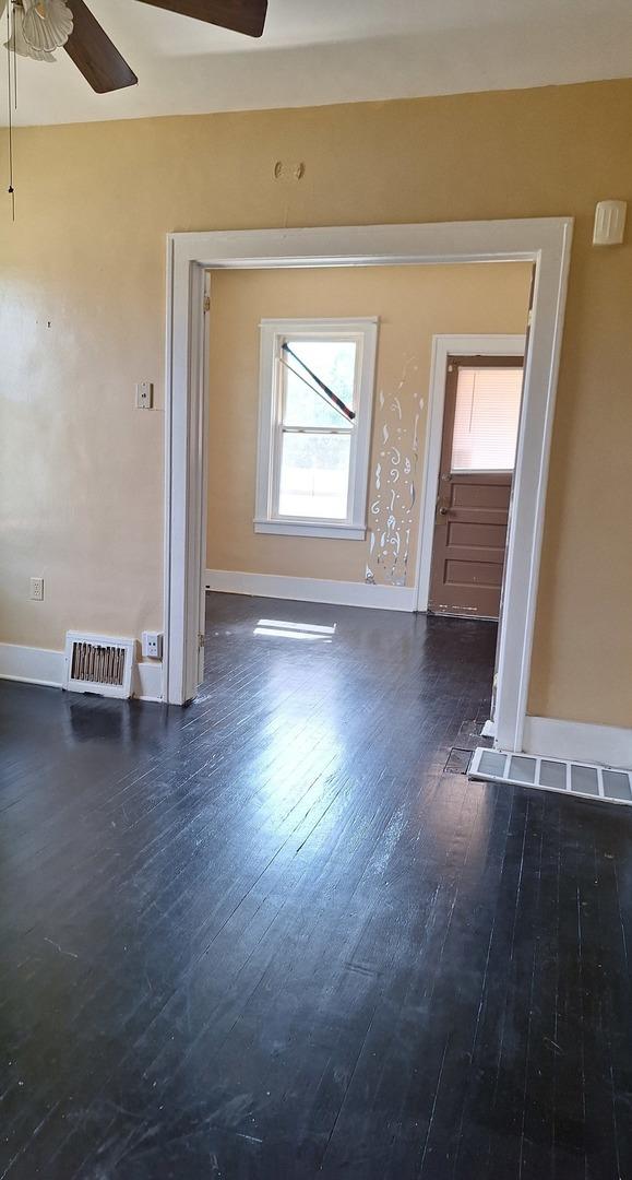 unfurnished room with dark hardwood / wood-style floors and ceiling fan