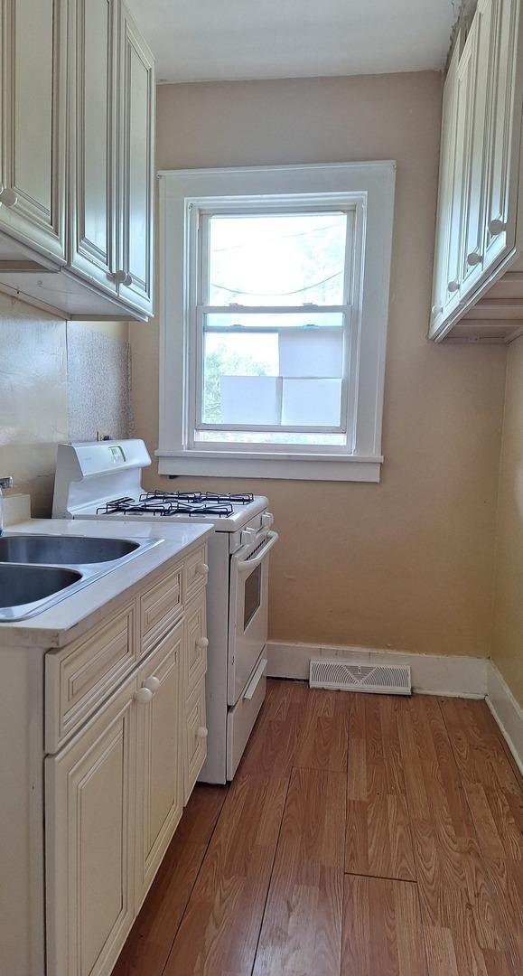 laundry area featuring light wood-type flooring and sink