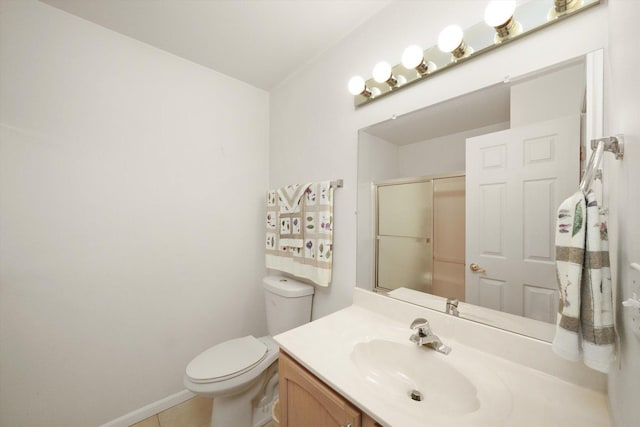 bathroom featuring tile patterned flooring, vanity, toilet, and walk in shower