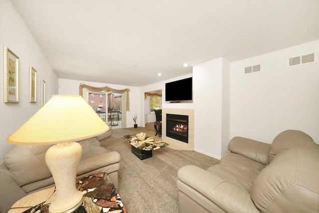 living room featuring carpet flooring and a tile fireplace