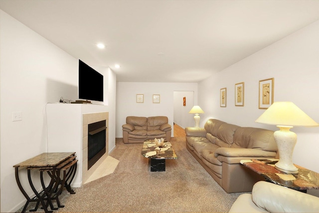 carpeted living room featuring a tiled fireplace