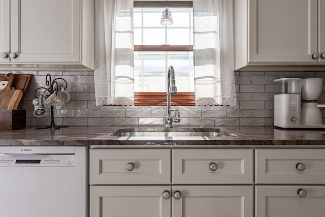 kitchen featuring white cabinetry, dishwasher, sink, and backsplash