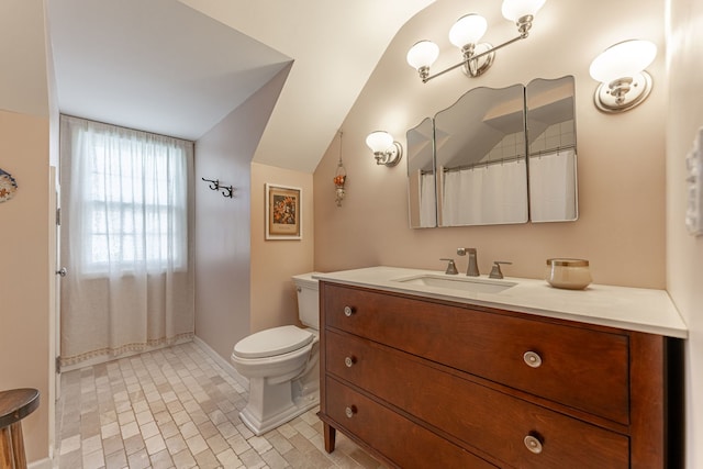 bathroom featuring vanity, vaulted ceiling, toilet, and walk in shower