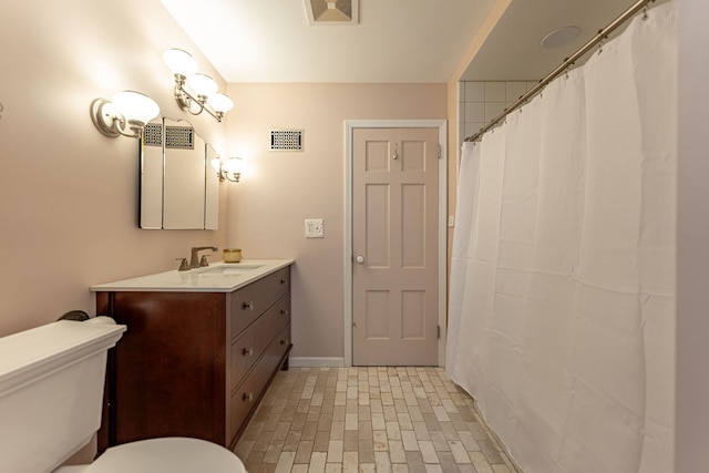 bathroom with vanity, walk in shower, and toilet