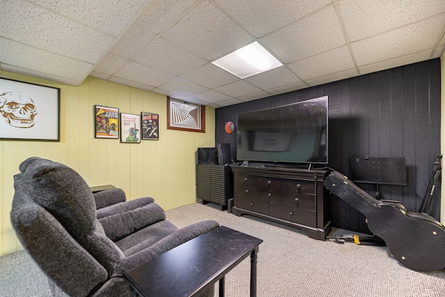 carpeted living room featuring a drop ceiling