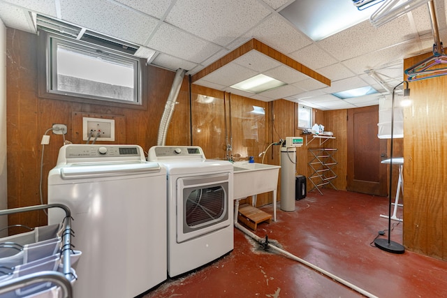 laundry room featuring washer and dryer and wooden walls