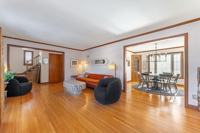 living room with an inviting chandelier, plenty of natural light, and light wood-type flooring