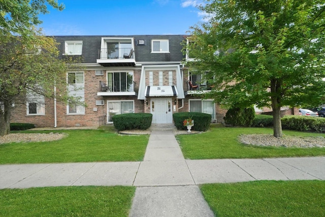 view of front of home featuring a front yard and a balcony