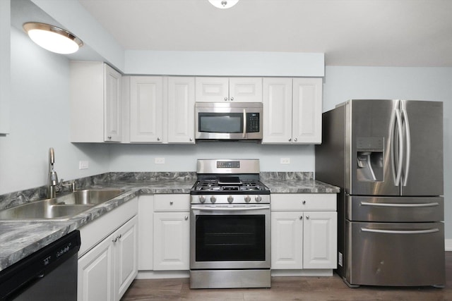 kitchen featuring appliances with stainless steel finishes, white cabinetry, and sink