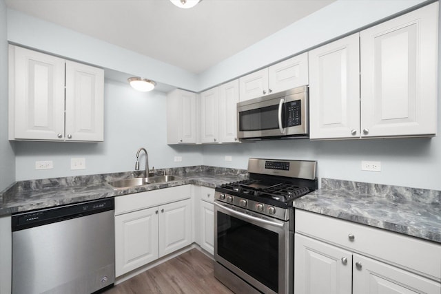 kitchen featuring white cabinetry, sink, appliances with stainless steel finishes, and dark wood-type flooring