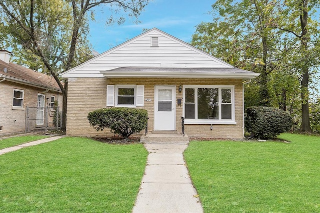 bungalow-style home with a front yard