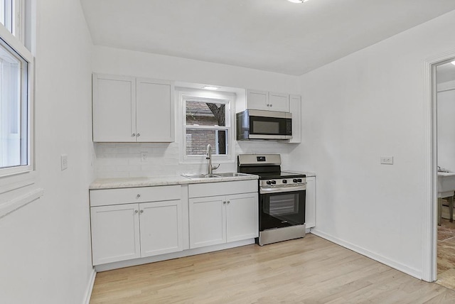 kitchen featuring white cabinetry, plenty of natural light, and appliances with stainless steel finishes