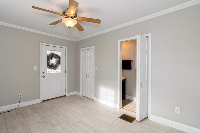 entryway with ceiling fan and crown molding