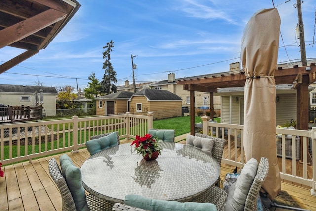 deck with a yard, a pergola, and an outbuilding