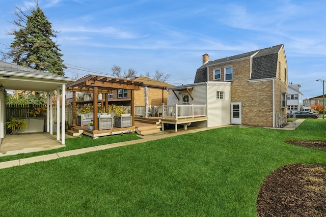 back of property with a pergola, a lawn, and a deck