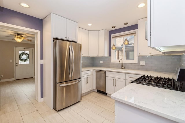 kitchen with light stone countertops, sink, white cabinets, and stainless steel appliances