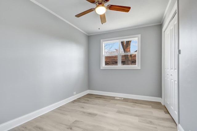 unfurnished bedroom featuring ceiling fan, a closet, light hardwood / wood-style floors, and ornamental molding