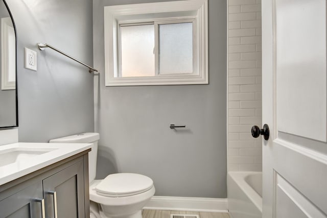 full bathroom with vanity, tiled shower / bath combo, and toilet