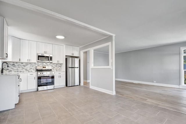 kitchen featuring appliances with stainless steel finishes, tasteful backsplash, white cabinetry, and sink