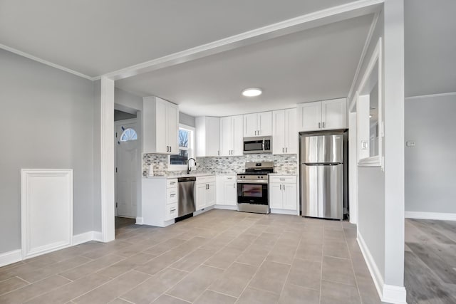 kitchen featuring crown molding, white cabinetry, sink, and appliances with stainless steel finishes