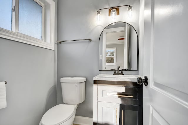 bathroom with vanity, toilet, and a healthy amount of sunlight