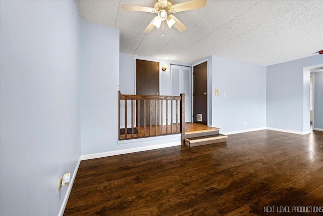 unfurnished room with a textured ceiling, dark hardwood / wood-style floors, and ceiling fan