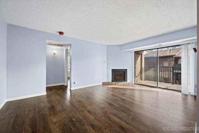 unfurnished living room featuring wood-type flooring and a textured ceiling