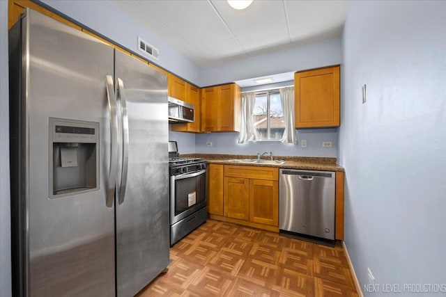 kitchen featuring dark parquet flooring, sink, and stainless steel appliances