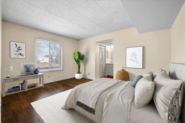 bedroom featuring a textured ceiling, dark hardwood / wood-style flooring, and ensuite bathroom