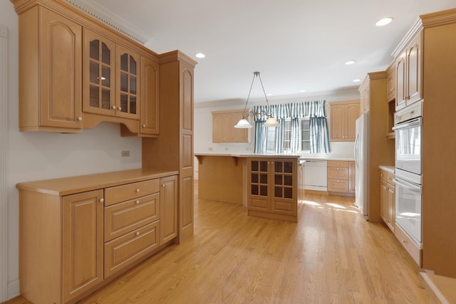 kitchen with white appliances, a kitchen island, ornamental molding, decorative light fixtures, and light hardwood / wood-style floors