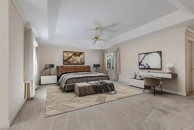 carpeted bedroom featuring a tray ceiling, ceiling fan, and ornamental molding