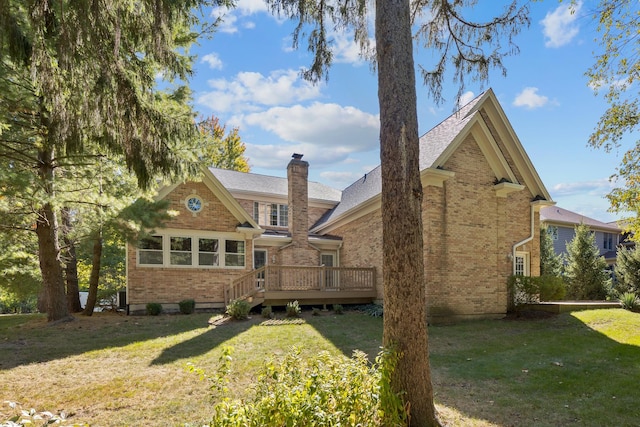 back of property featuring a lawn and a deck