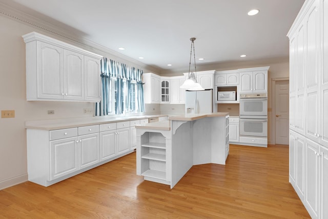 kitchen with pendant lighting, white appliances, white cabinetry, and a kitchen island