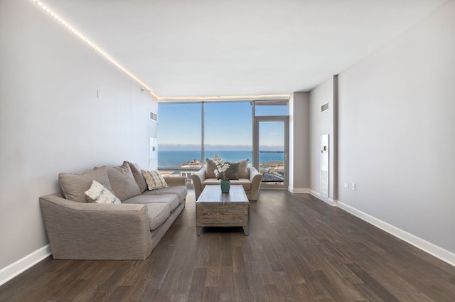 living room with floor to ceiling windows, a water view, and dark hardwood / wood-style floors