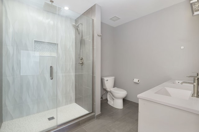 bathroom featuring tile patterned flooring, vanity, toilet, and a shower with door