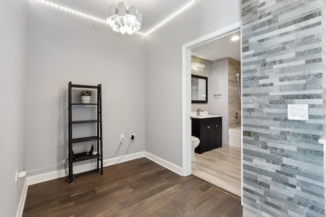 interior space featuring dark wood-type flooring, a notable chandelier, and sink