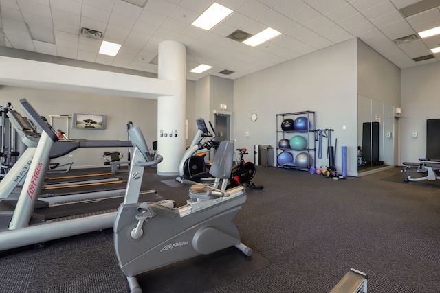 gym featuring a paneled ceiling and a high ceiling