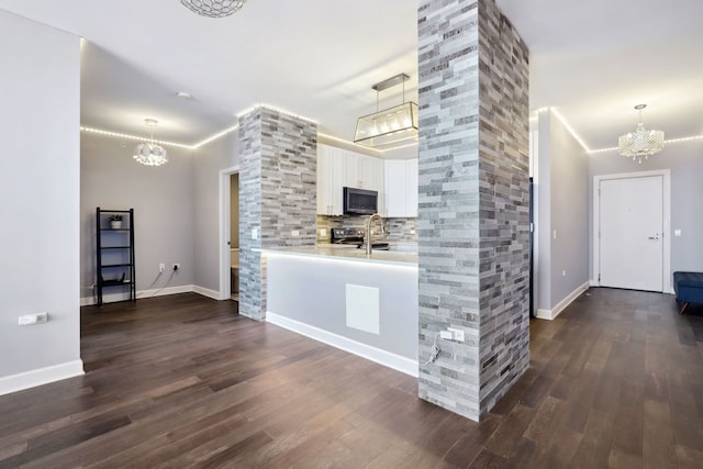 kitchen featuring white cabinets, pendant lighting, stainless steel appliances, and dark hardwood / wood-style floors