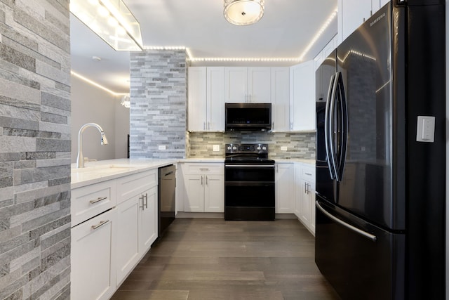 kitchen with backsplash, black appliances, sink, dark hardwood / wood-style floors, and white cabinetry