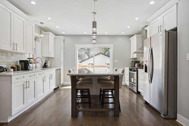 kitchen with white cabinets, decorative light fixtures, stainless steel appliances, and dark wood-type flooring