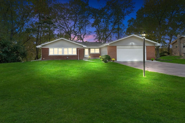 ranch-style home with a garage and a yard