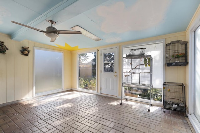 unfurnished sunroom featuring ceiling fan