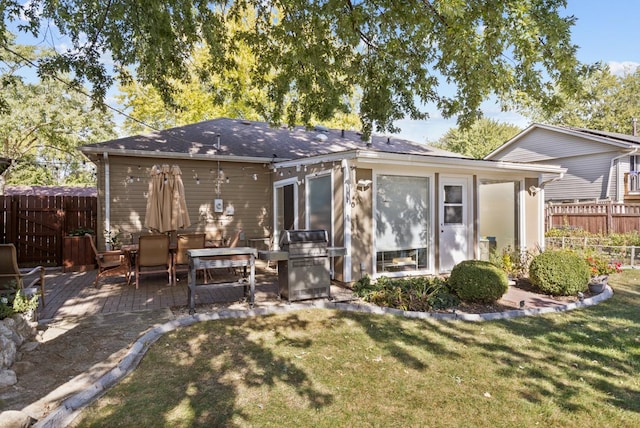 rear view of property featuring a yard and a patio area