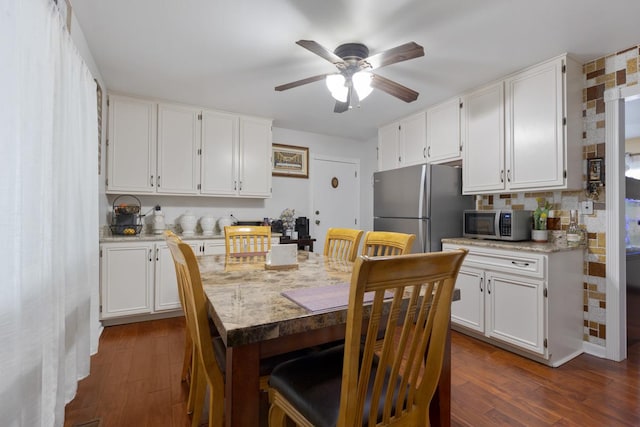 kitchen with white cabinets, appliances with stainless steel finishes, and dark hardwood / wood-style floors