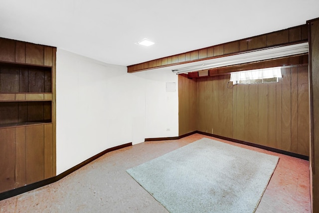 unfurnished room featuring wooden walls